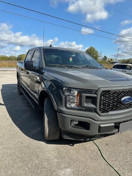 Completed grey Ford F-150 from the front three-quarter after repair