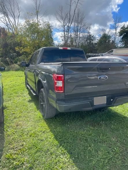 Completed grey Ford F-150 from the side after repair